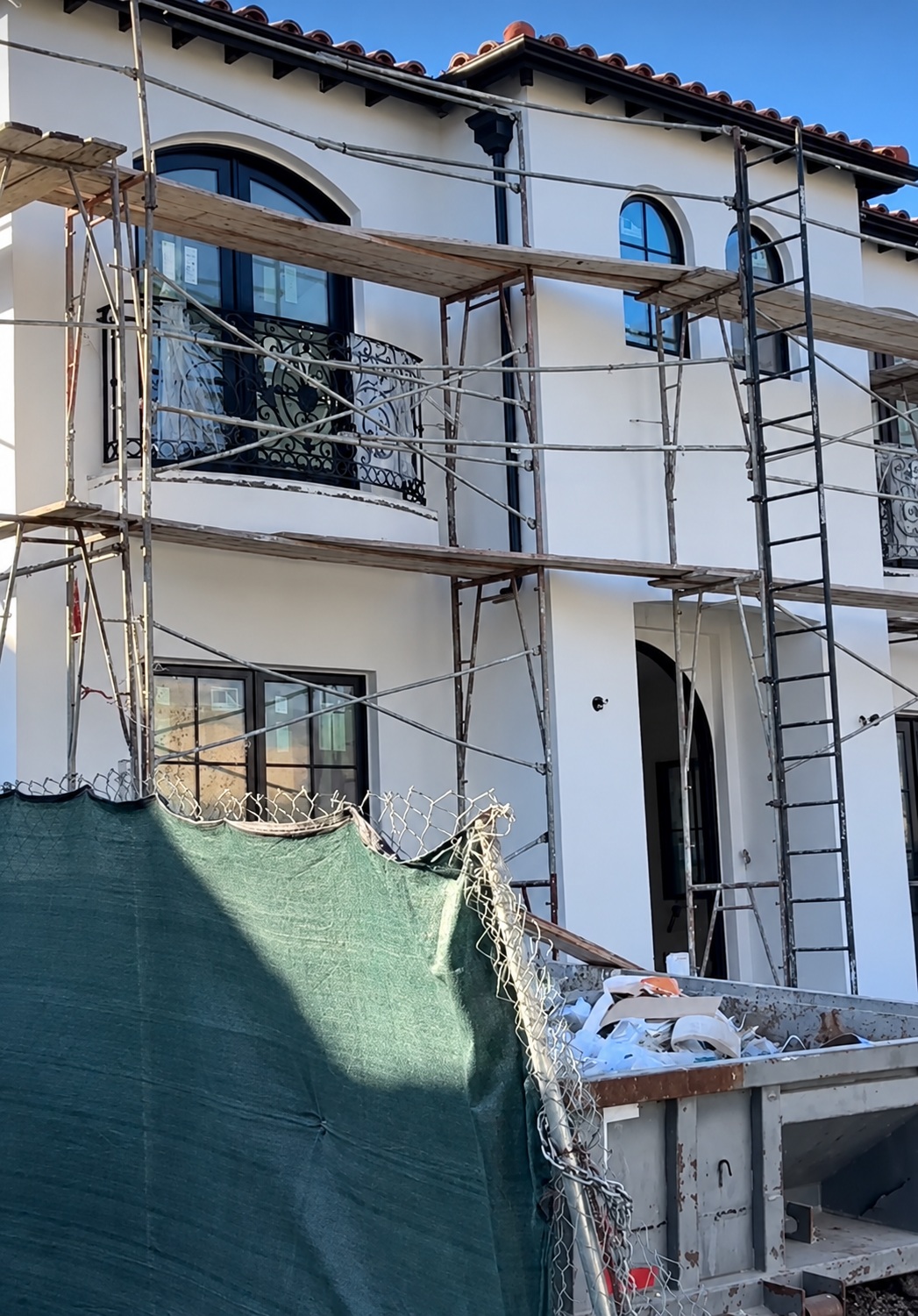 Exterior construction with scaffolding around the new second story