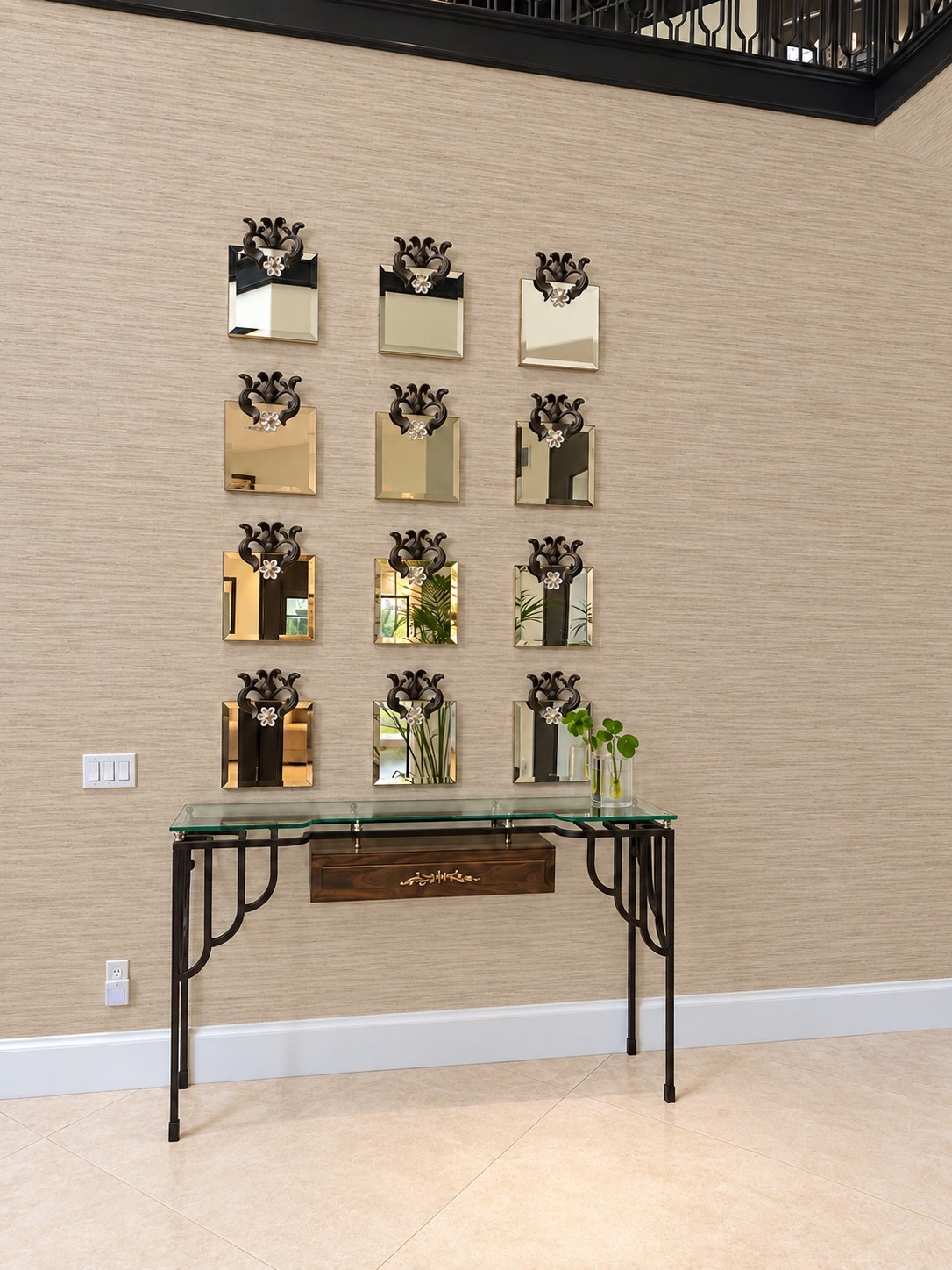 Foyer console beneath a collection of small mirrors