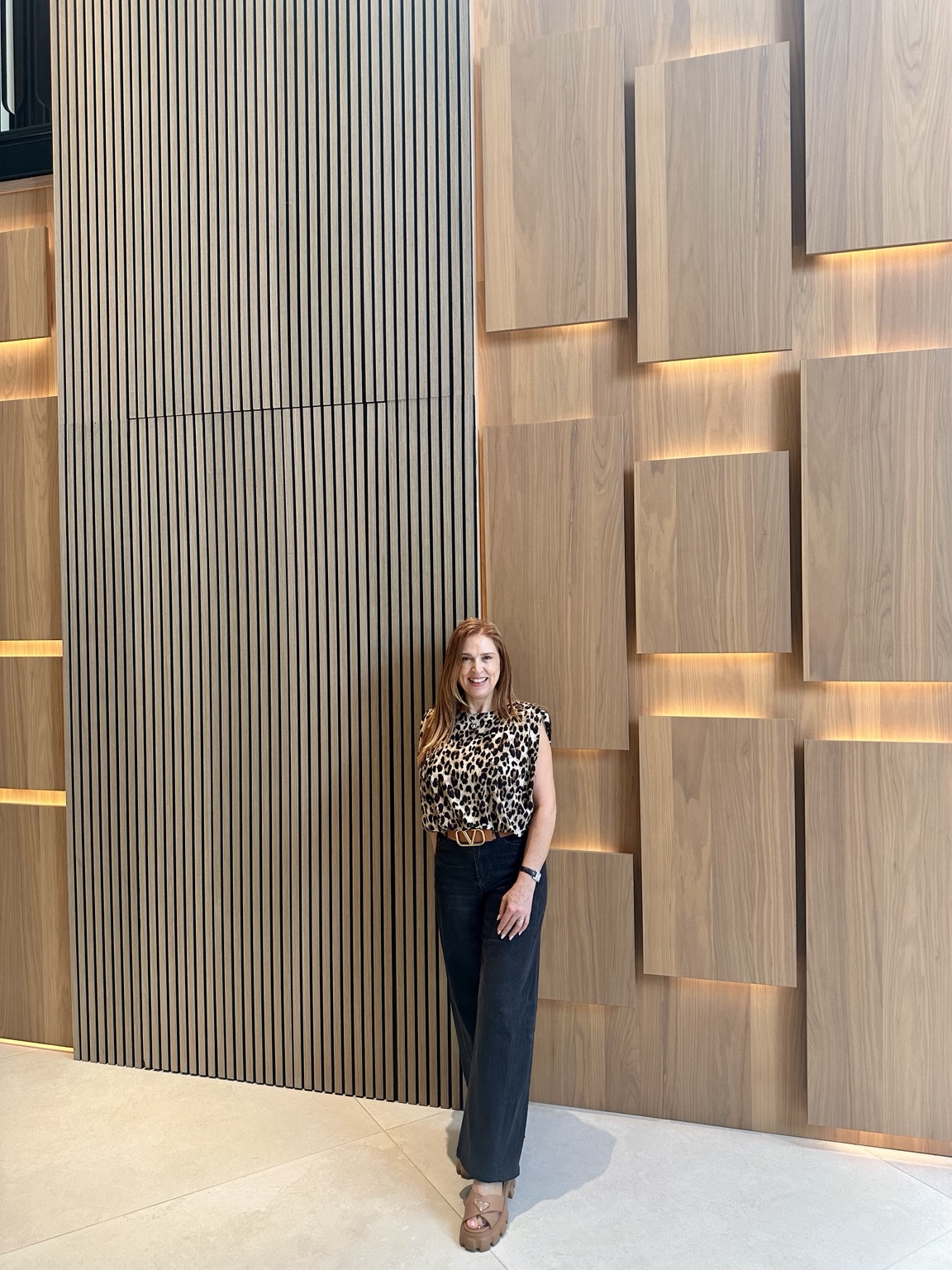 Ziba Shamoeil in front of the illuminated wood feature wall at Brentwood Park Residence