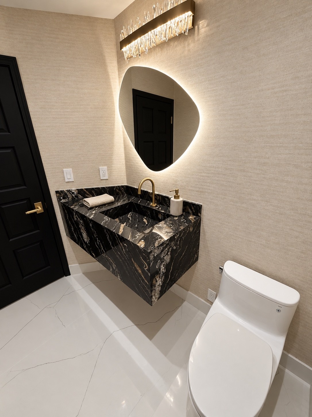 Powder room with sculptural illuminated mirror and dark stone vanity