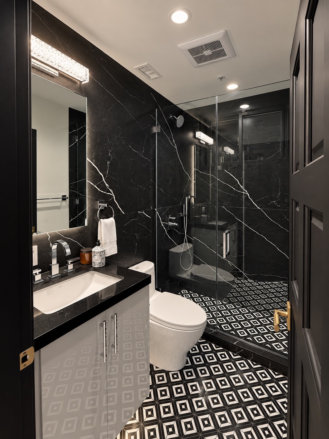 Glass shower enclosure and geometric tile flooring